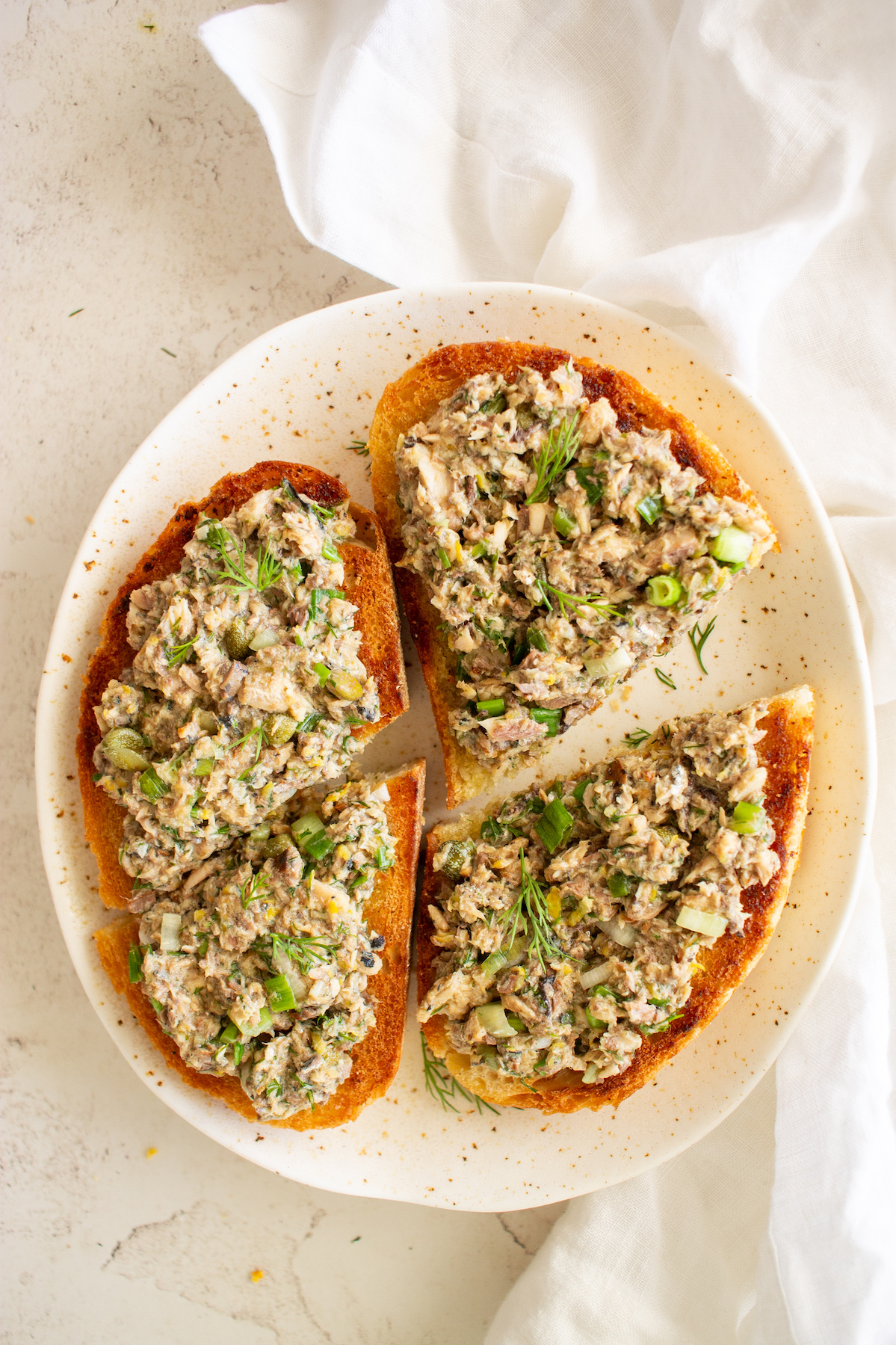 Sardine salad spread over 2 slices of bread.