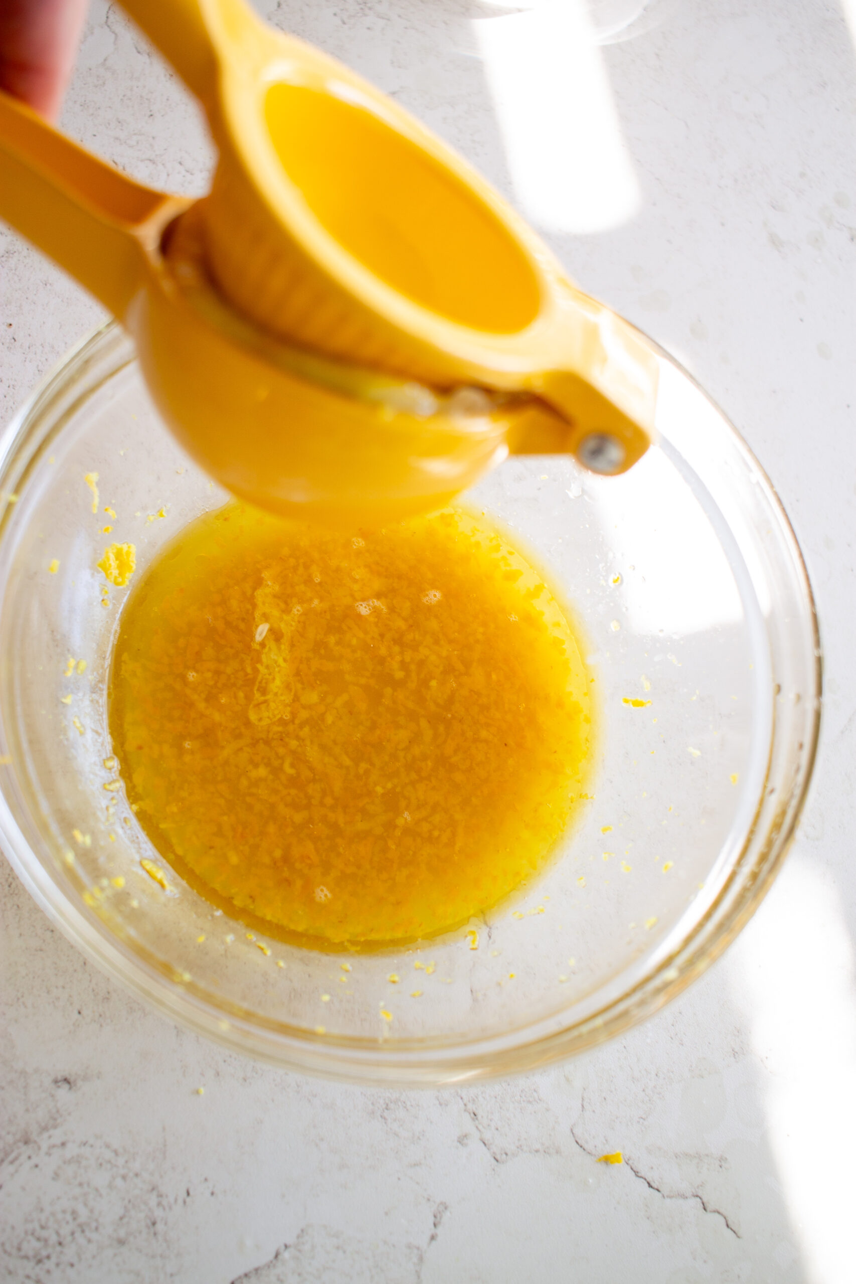 Squeezing lemon with a lemon squeezer.