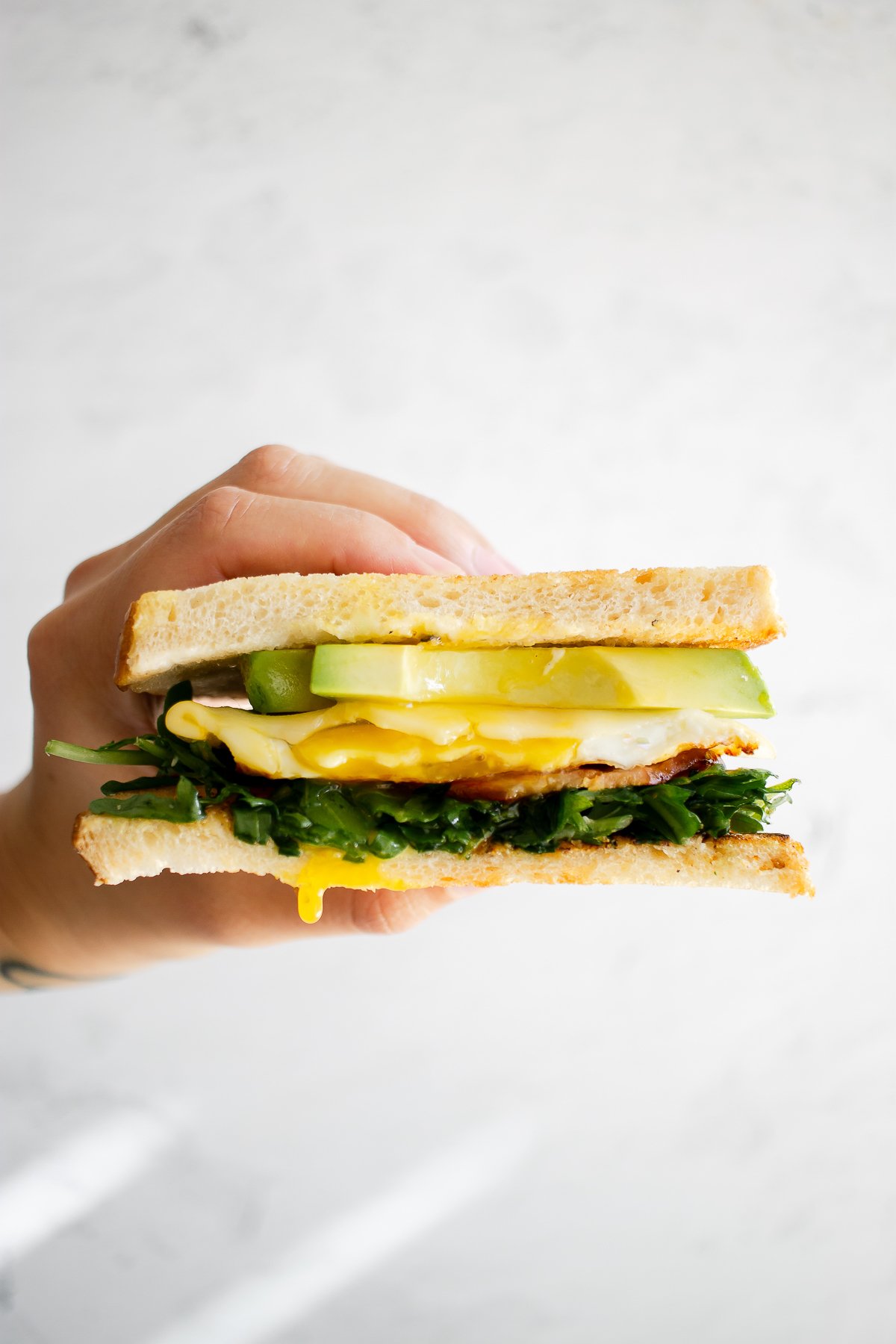 hand holding sourdough bread breakfast sandwich blog edit 1
